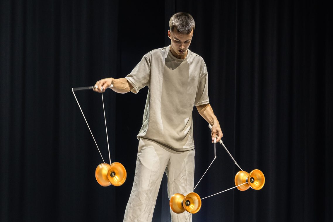 Ein junger Artist der Diabolo-Kunst zeigt vollen Einsatz und konzentriert sich ganz auf sein Requisit, während er die Hände voll zu tun hat