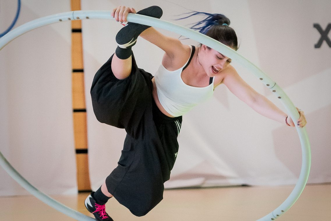 Fast parallel zum Boden: Eine junge Artistin zeigt in einem Cyr Wheel eine spektakuläre Figur, bei der sie ein Bein nach oben streckt
