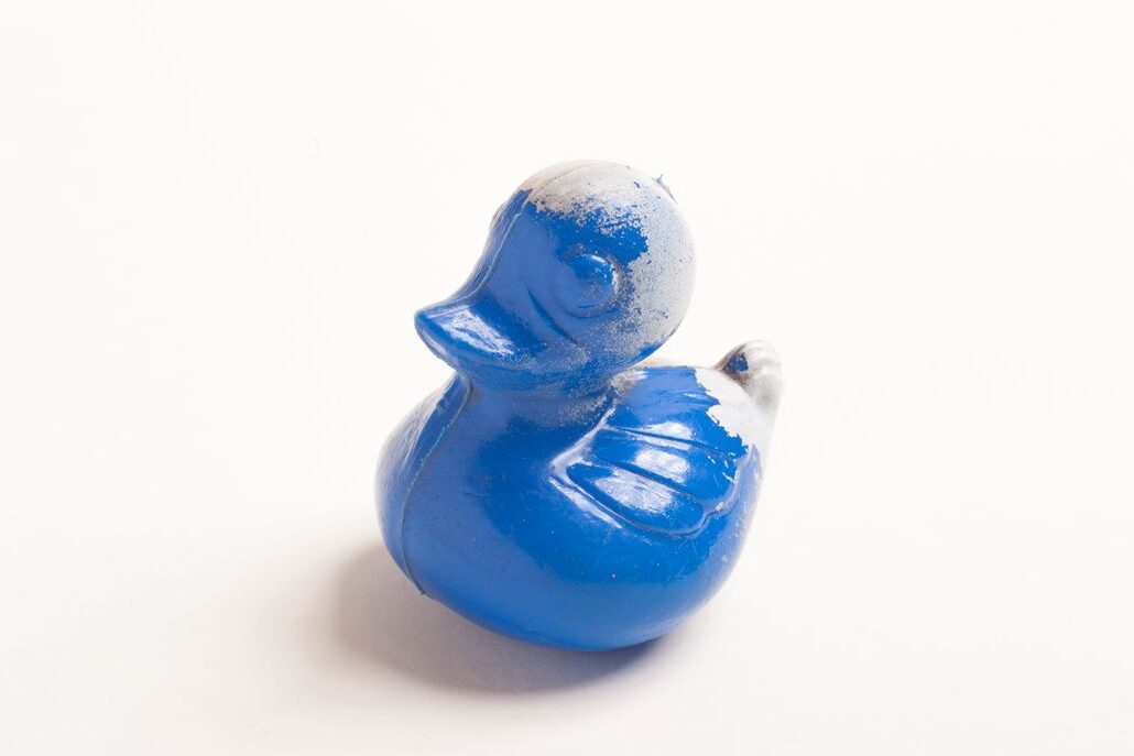 Blue swimming ducks with peeling paint on the back of the head and tail
