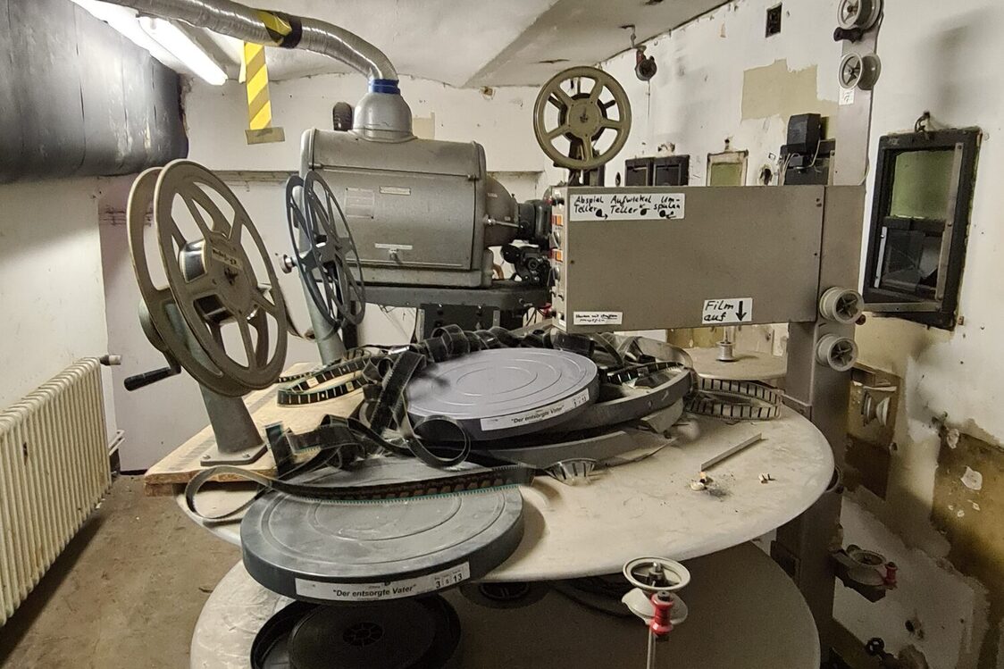 Historical film projection machine with filmstrips in the foreground