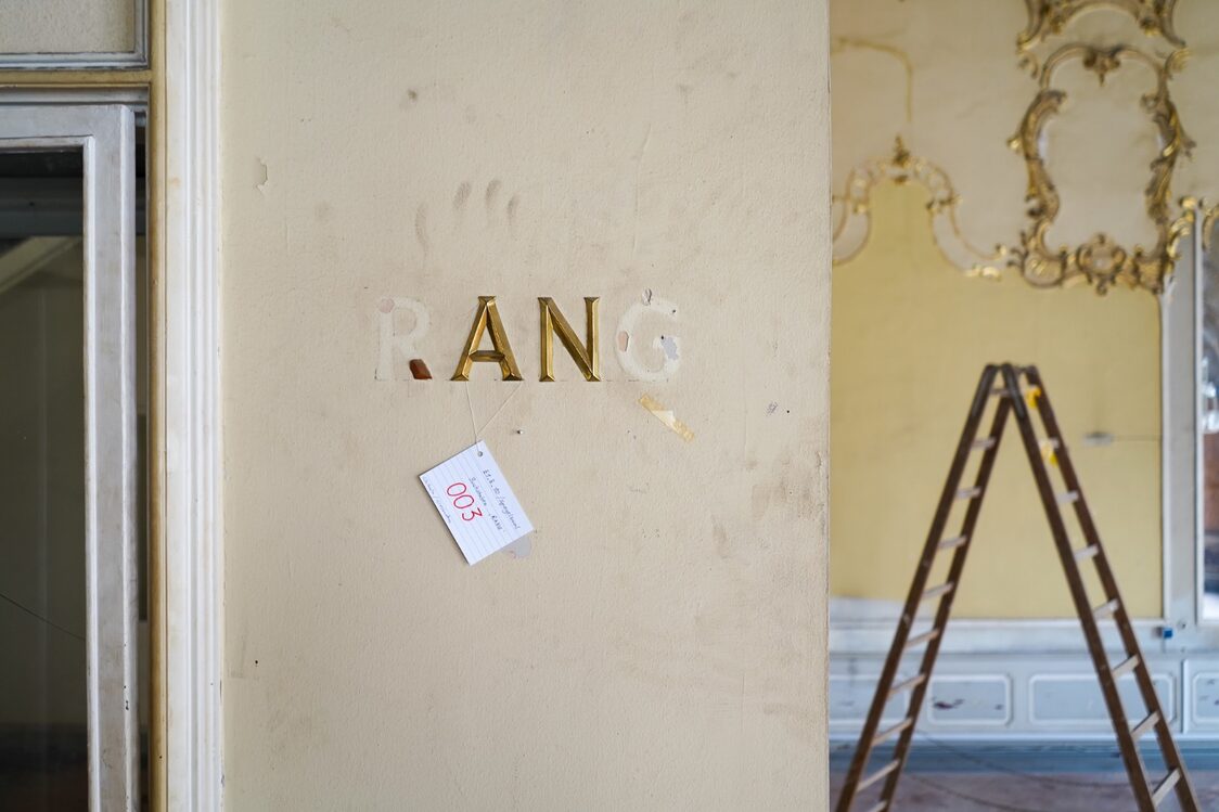 Remains of the inscription "RANG" on a wall in the Hall of Mirrors
