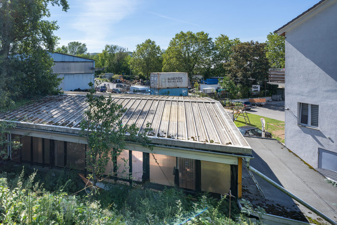 Kleinere Gewerbehallen, Container und gelagertes Metall prägen den Teuerborn.