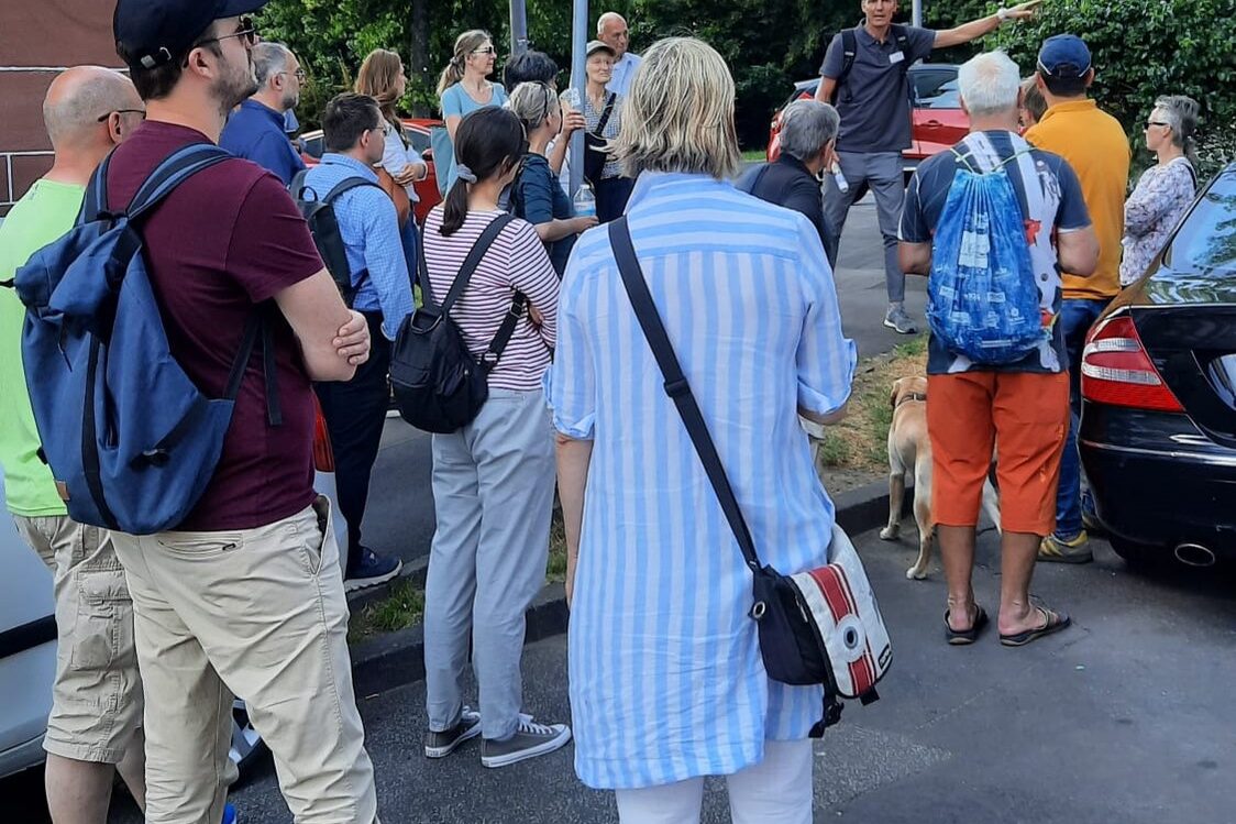 Grupa mężczyzn i kobiet stoi na parkingu.