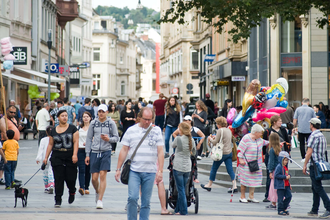 In der Fußgängerzone ist ein geschäftiges Treiben voller verschiedener Menschen.