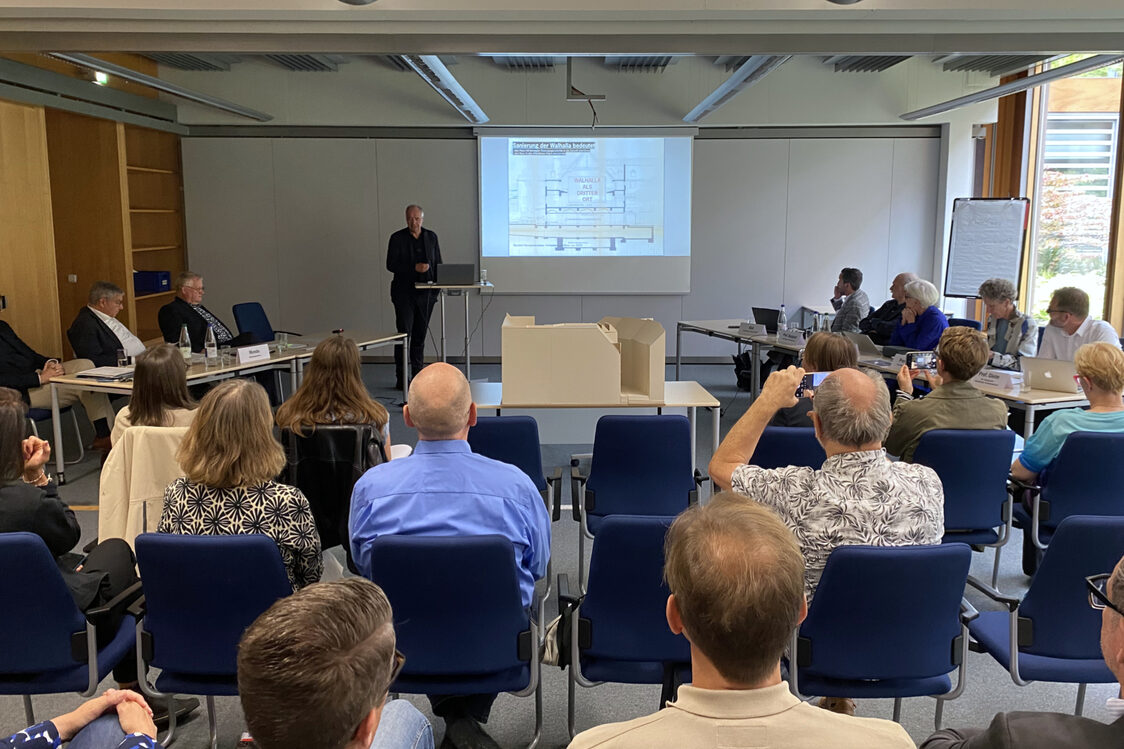 Мъж представя проект пред консултативния съвет и други членове на публиката.