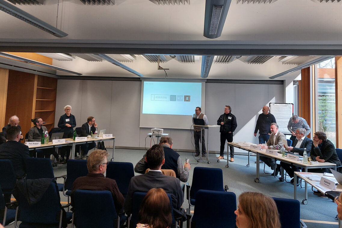 In einem Sitzungsraum wird den Mitgliedern des Gestaltungs- und Denkmalbeirats und dem Publikum eine Idee präsentiert.