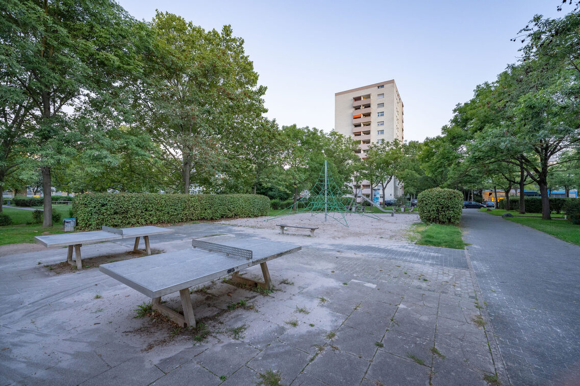 Spielplatz mit zwei Tischtennisplatten und einem Klettergerüst