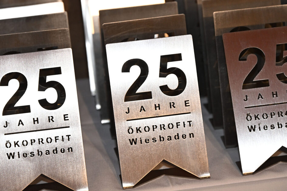 Drei Metalltafeln mit der Gravur 25 Jahre Ökoprofit Wiesbaden.