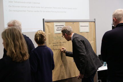 Seminarteilnehmende vor einer Pinnwand