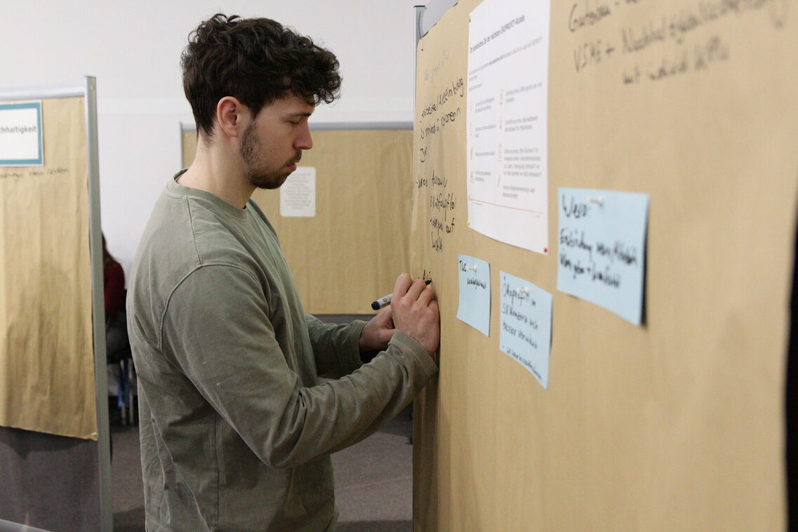 Άνθρωπος γράφει σε έναν πίνακα καρφιτσών