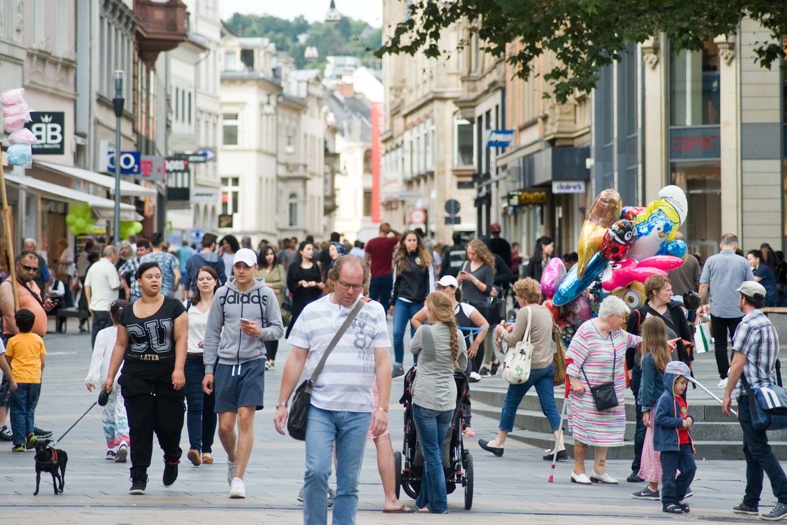In der Fußgängerzone ist ein geschäftiges Treiben voller verschiedener Menschen.