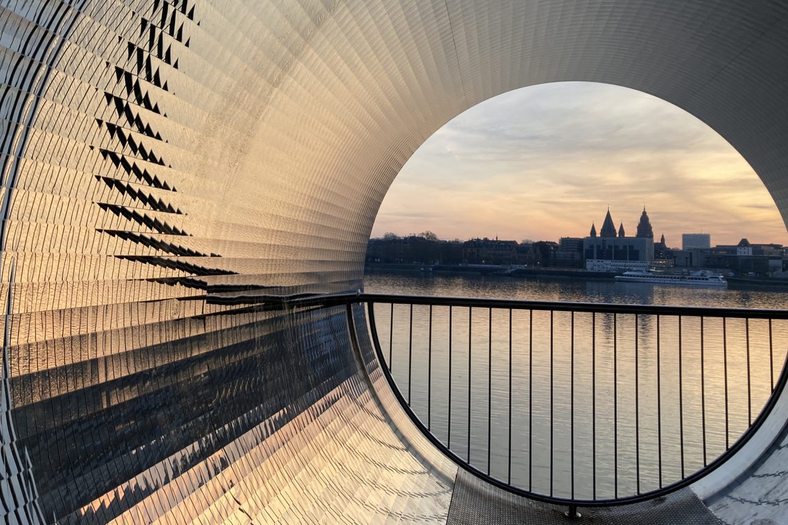 In der Skulptur, mit Blick auf den Mainzer Dom und das Rathaus, spiegelt sich das Abendlicht.