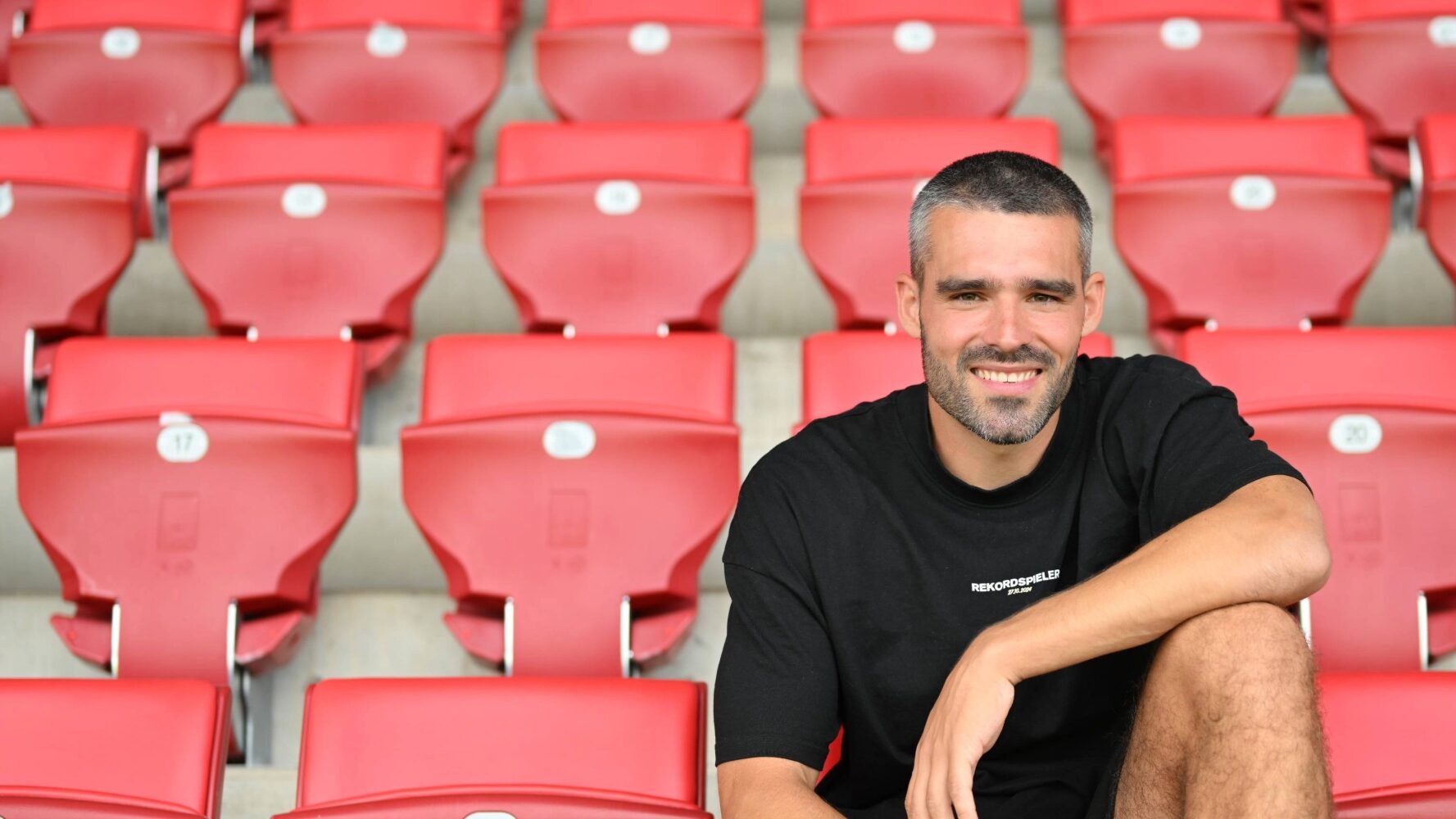 Mann auf Tribüne eines Fu0ßballstadions