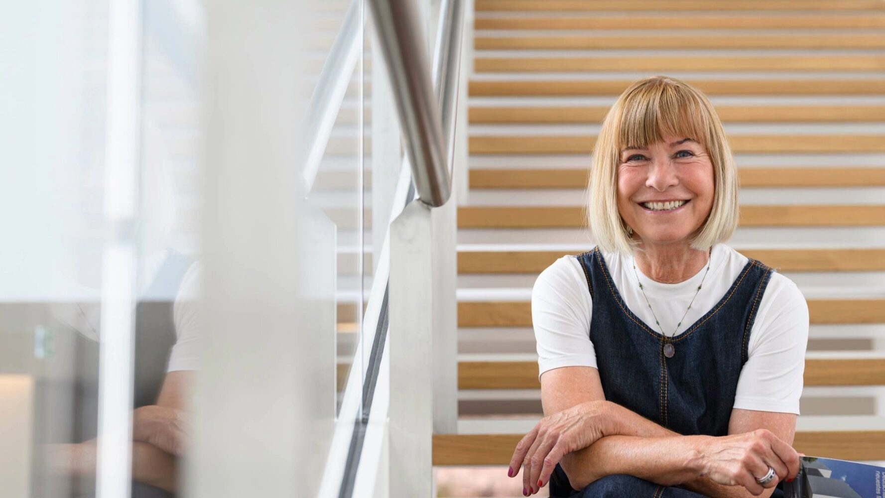 Frau sitzt auf einer Treppe in einem modernen Gebäude.
