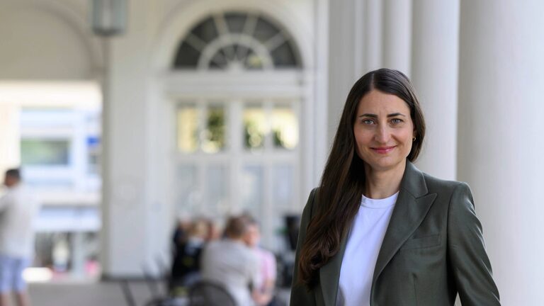 Frau mit dunklen Haaren vor historischem Gebäude