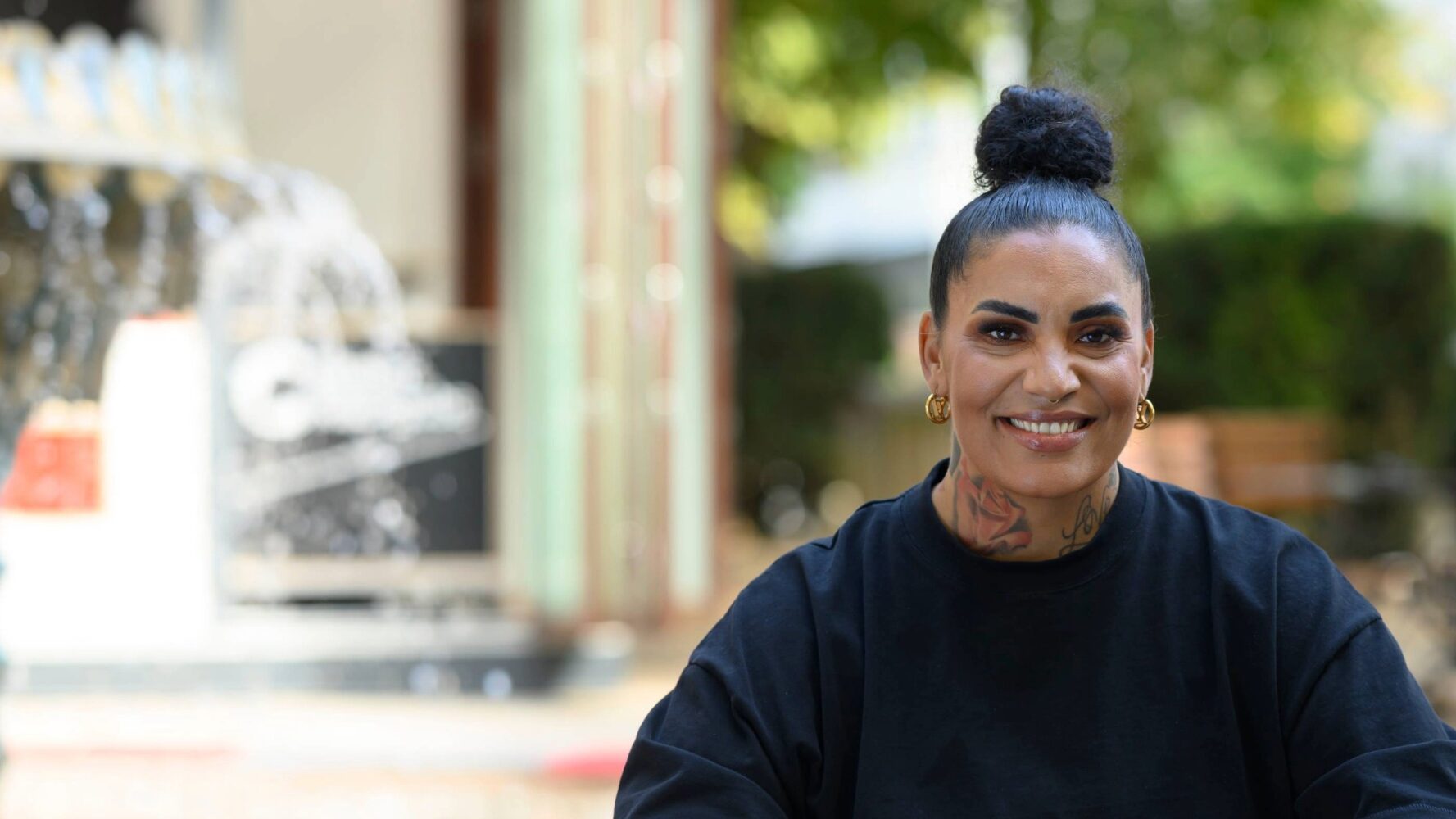 Frau sitzt vor großem Brunnen