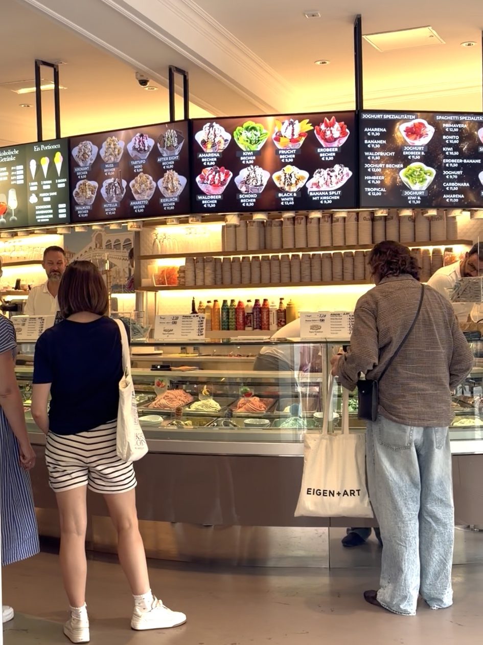 Menschen stehen vor Eisvitrine