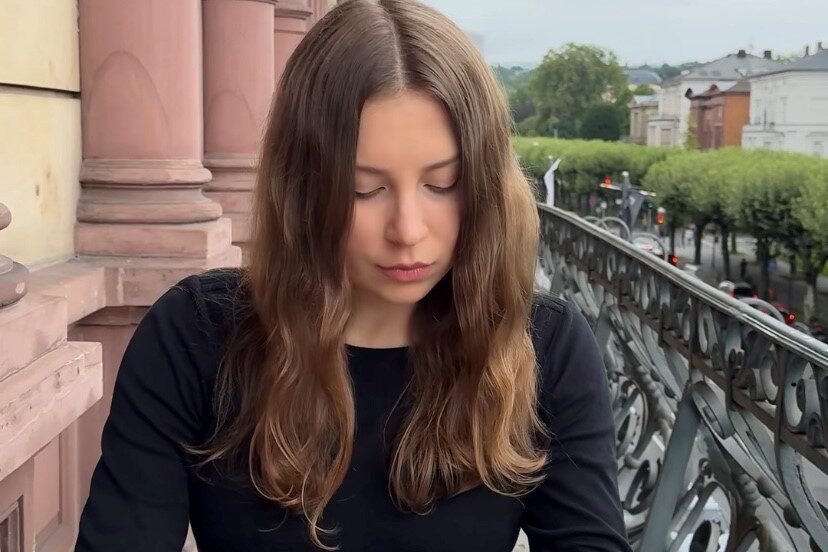 Junge Frau mit braunen Haaren mit Skizzenbuch