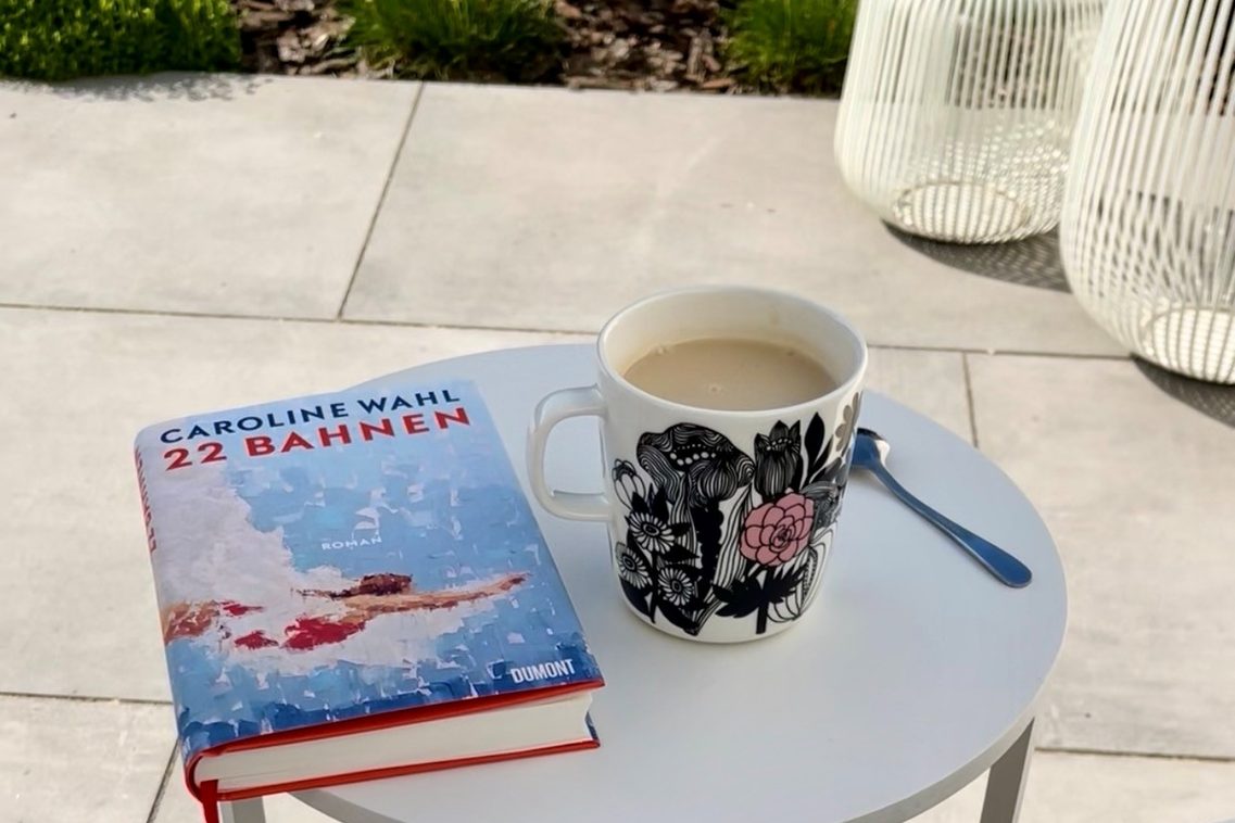 Blick in Garten mit Buch und Tee