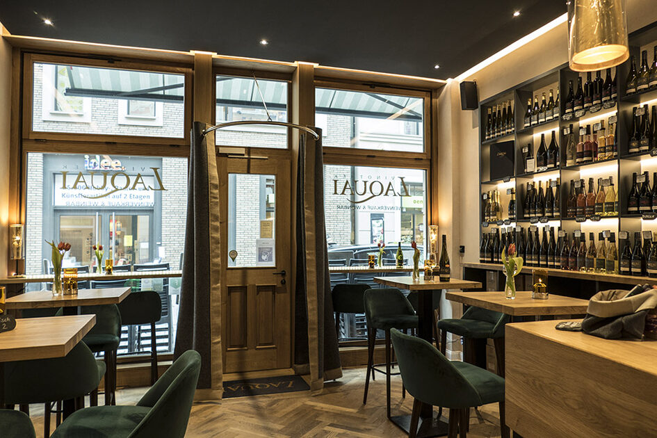 View of the wine bar with high tables and wooden shelves