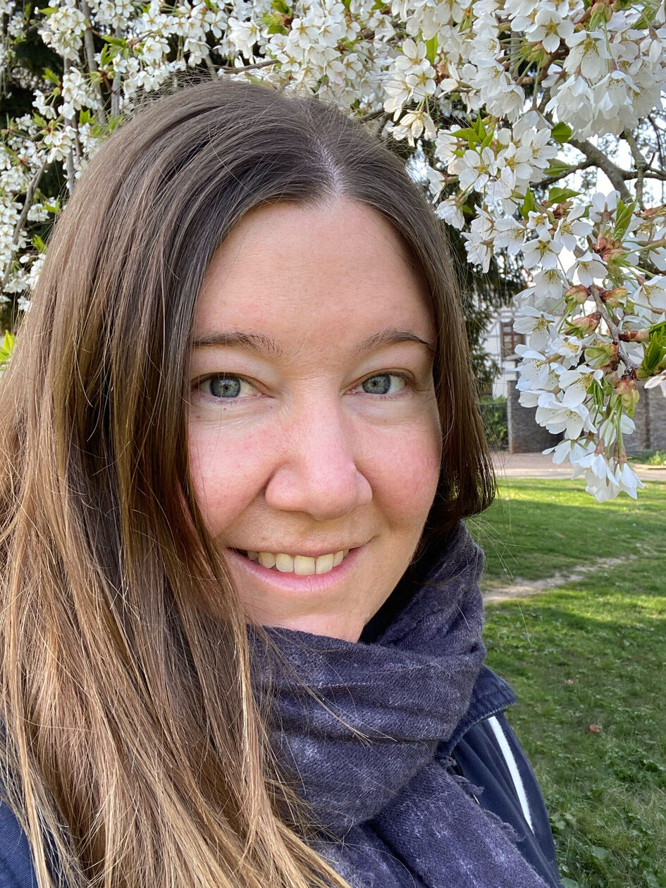 Young woman in front of blossoming trees