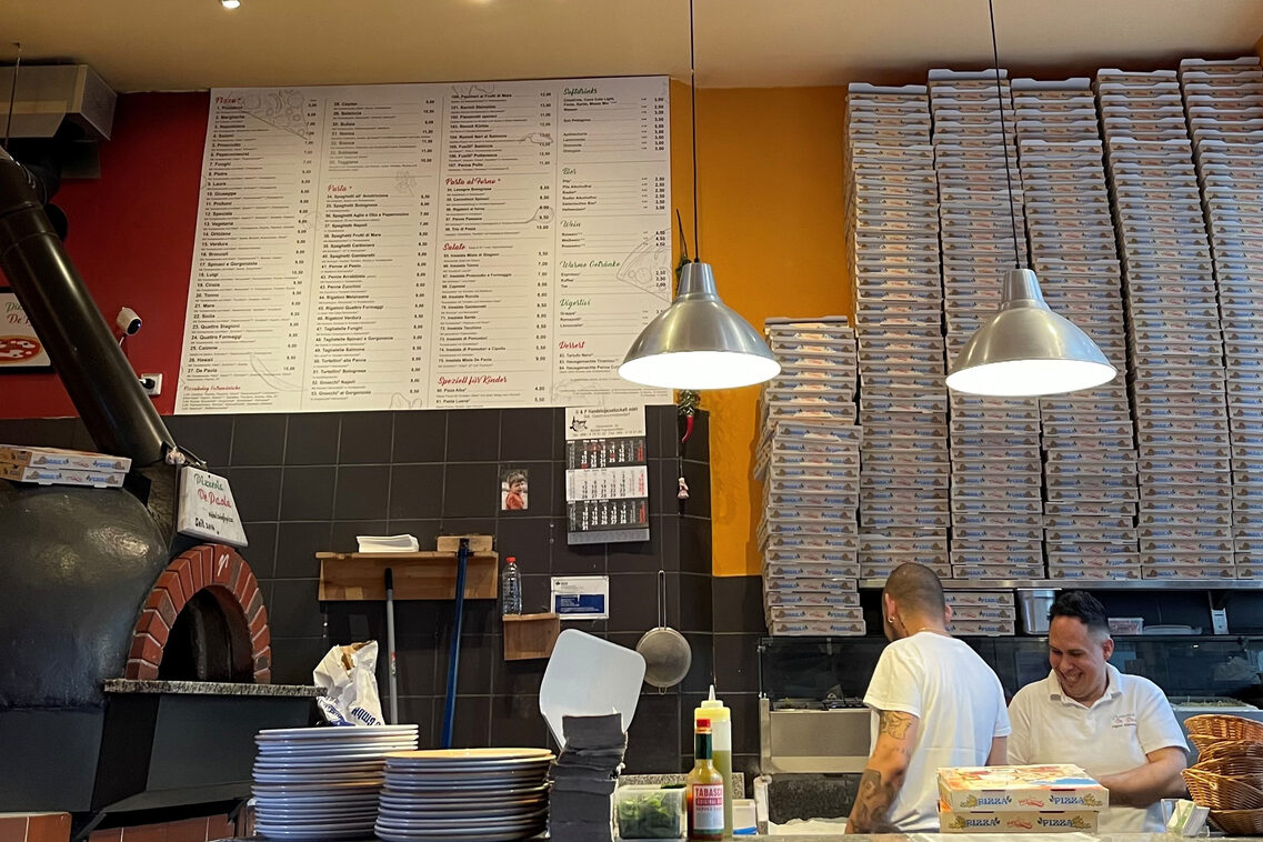Counter at Pizzeria De Paola with pizza boxes
