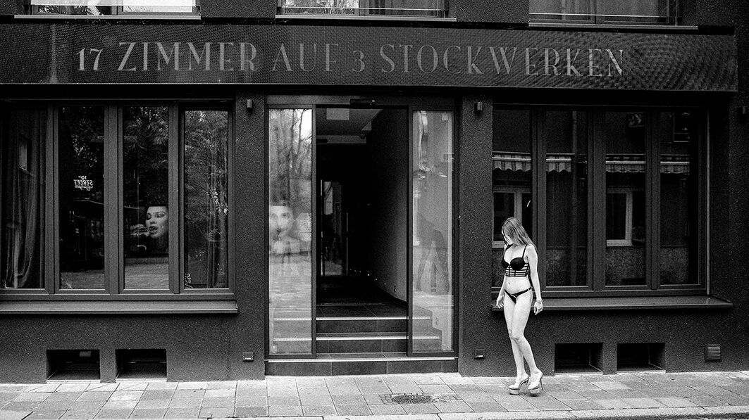 Eine Prostituierte vor einem Laufhaus schwarz weiß fotografiert