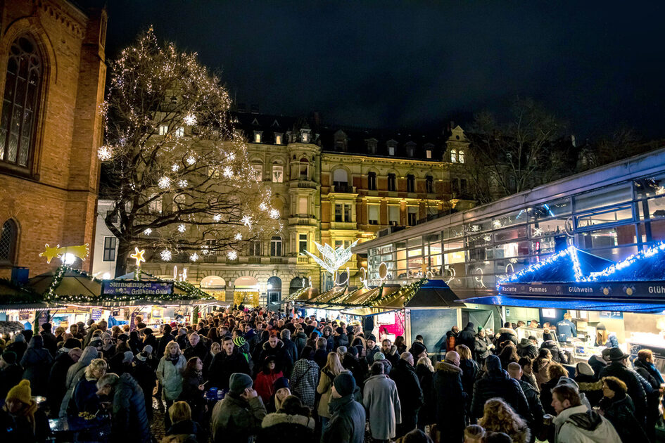 Verschiedene Weihnachtsbuden mit Menschen davor