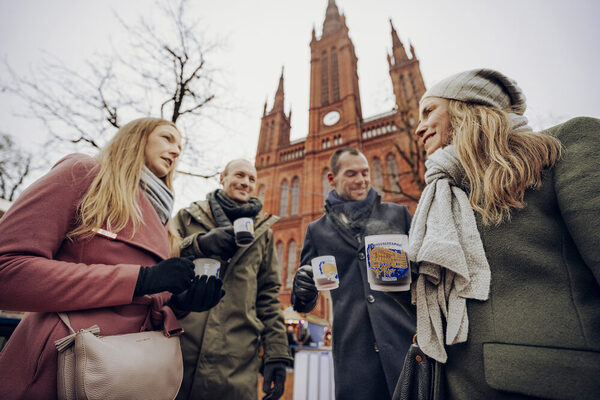 Zwei Frauen und zwei Männer mit Glühweintassen in der Hand