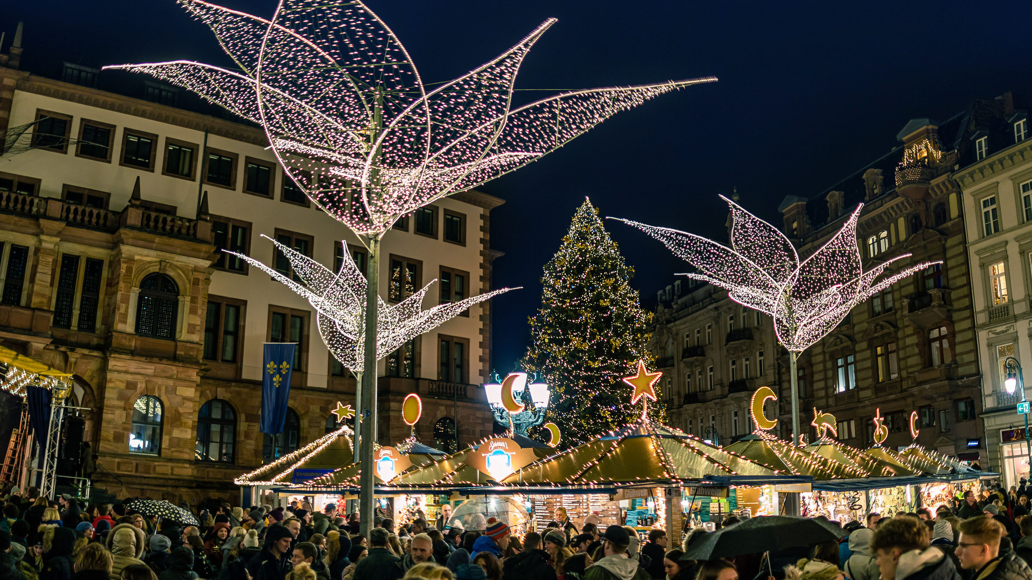 Tannenbaum mit verschiedenen Buden und Menschen