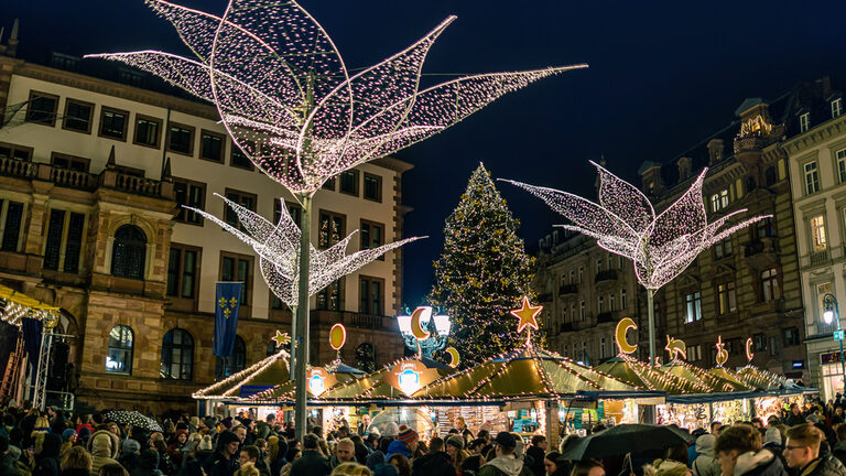 Tannenbaum mit verschiedenen Buden und Menschen