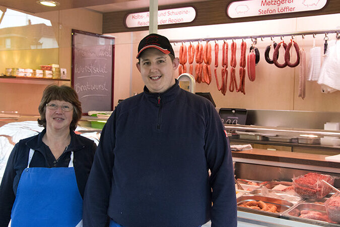Landmetzgerei Löffler - Mann und Frau vor Verkaufswagen
