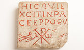 Quadratischer Grabstein mit roter Inschrift in lateinischer Sprache sowie