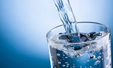 Wasser fließt in ein Wasserglas
