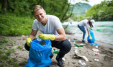 Junge Menschen sammeln Müll am Fluss