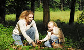 Frau mit Kind beim Pilze-Sammeln
