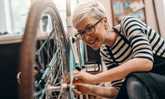 Frau, die ein Fahrrad repariert