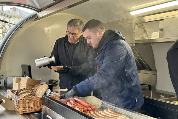Oberbürgermeister Gert-Uwe Mende (links) verkaufte am Streetfood-Wagen der Wiesbadener Kochwerkstatt Currywurst für einen guten Zweck.