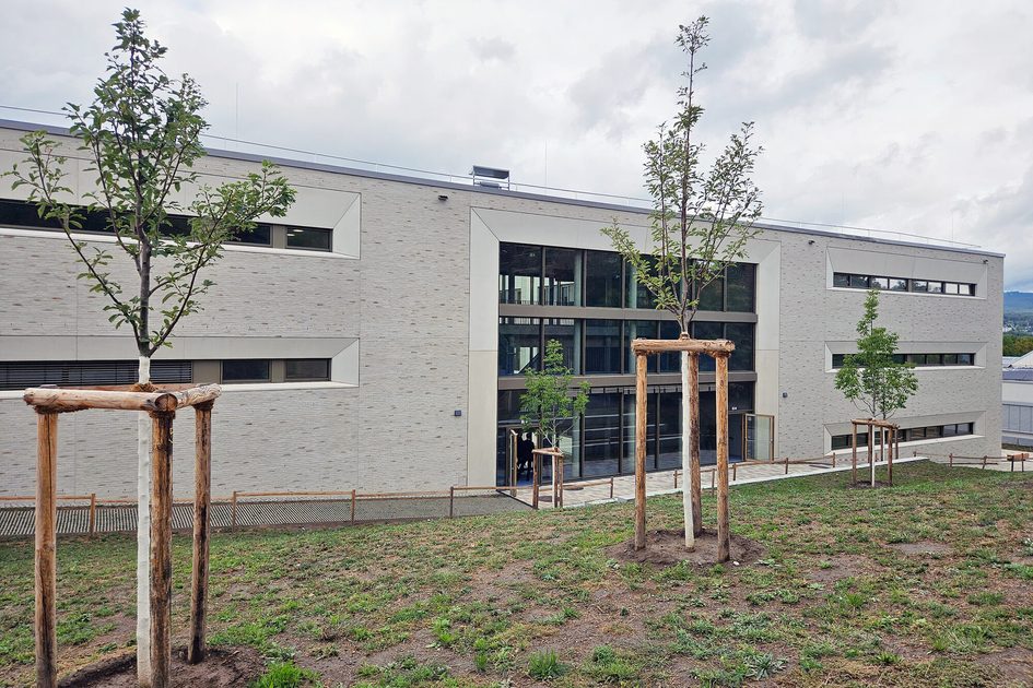 Auf dem Foto sind der Erweiterungsbau der Martin-Niemöller-Schule sowie neu gepflanzte Bäume zu sehen.