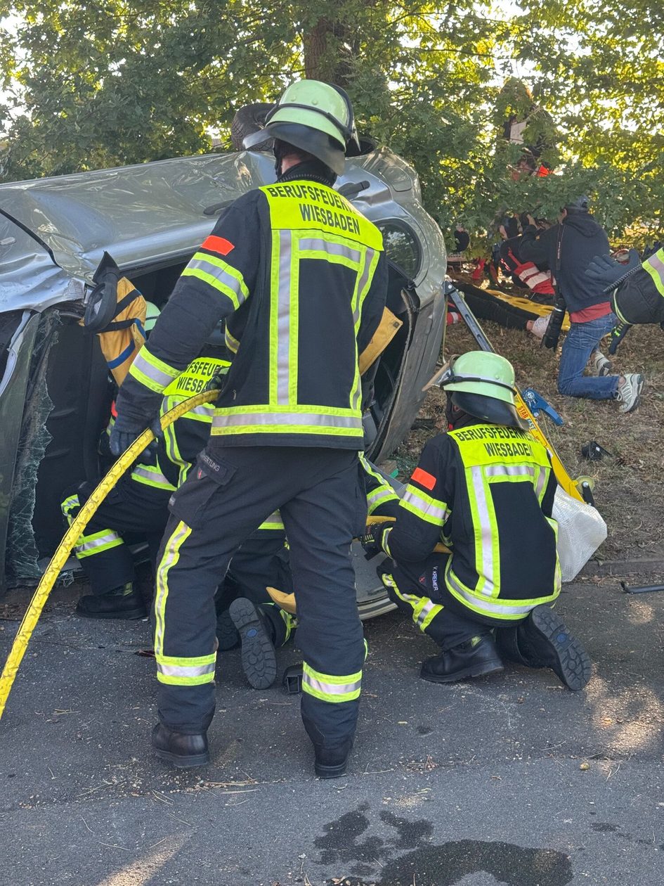Feuerwehrkräfte bei der Rettung an einem Unfallauto