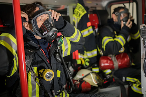 Berufsfeuerwehrmänner beim Ausrüsten im HLF