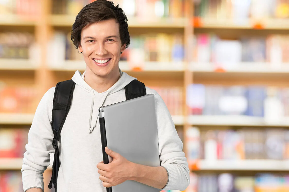 Junger Mann mit Laptop auf dem Arm