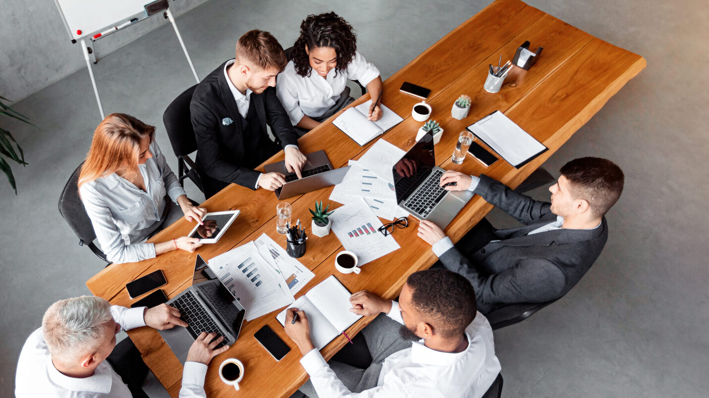 Colegas Hablando Sentados Con Gadgets Durante Reunión En Oficina, Ángulo Alto