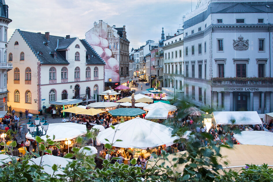 Blick auf Volksfest. Viele Stände mit vielen Menschen.