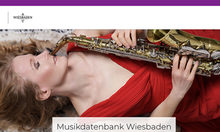 Microsite Musikdatenbank - Frau im roten Kleid spielt Saxophon.