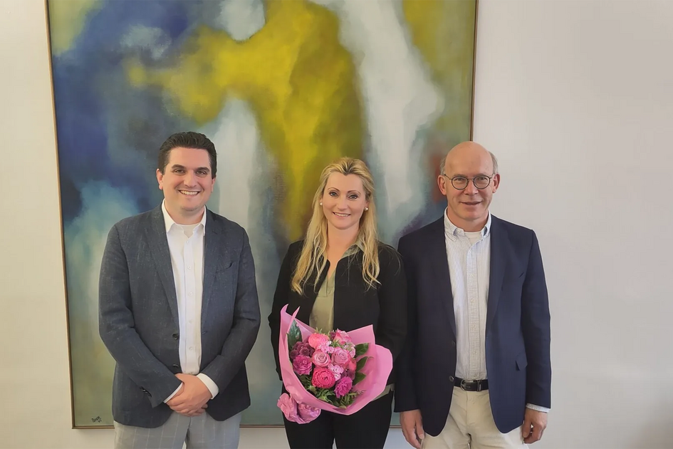 Zwei Männer und eine Frau vor einem Gemälde.