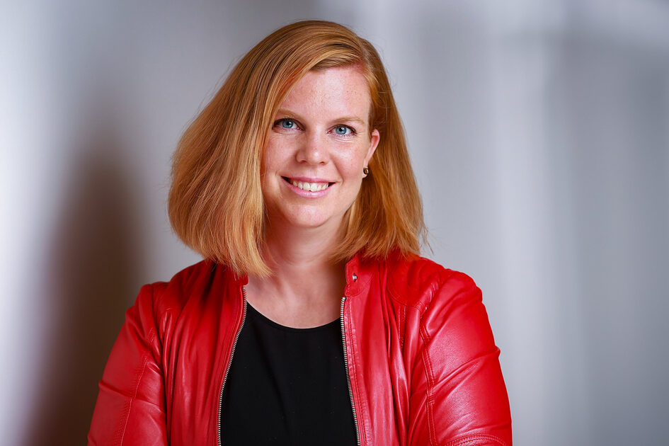 Женщина с рыжими волосами и в красной куртке