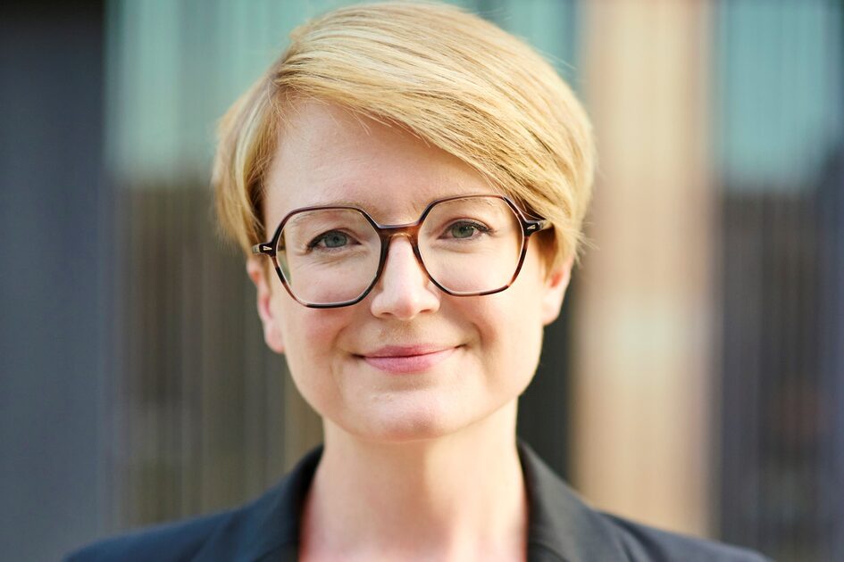 Femeie tânără cu păr roșu, scurt și ochelari