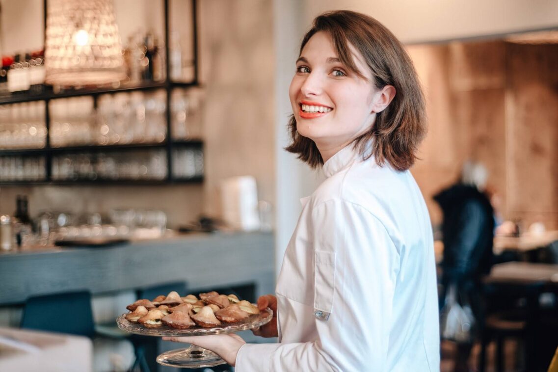 Frau in weißem Hemd schaut in Kamera