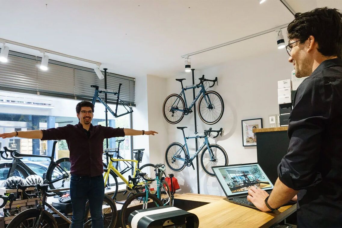 Mann wird vermessen - im Radladen vor vielen Rädern.